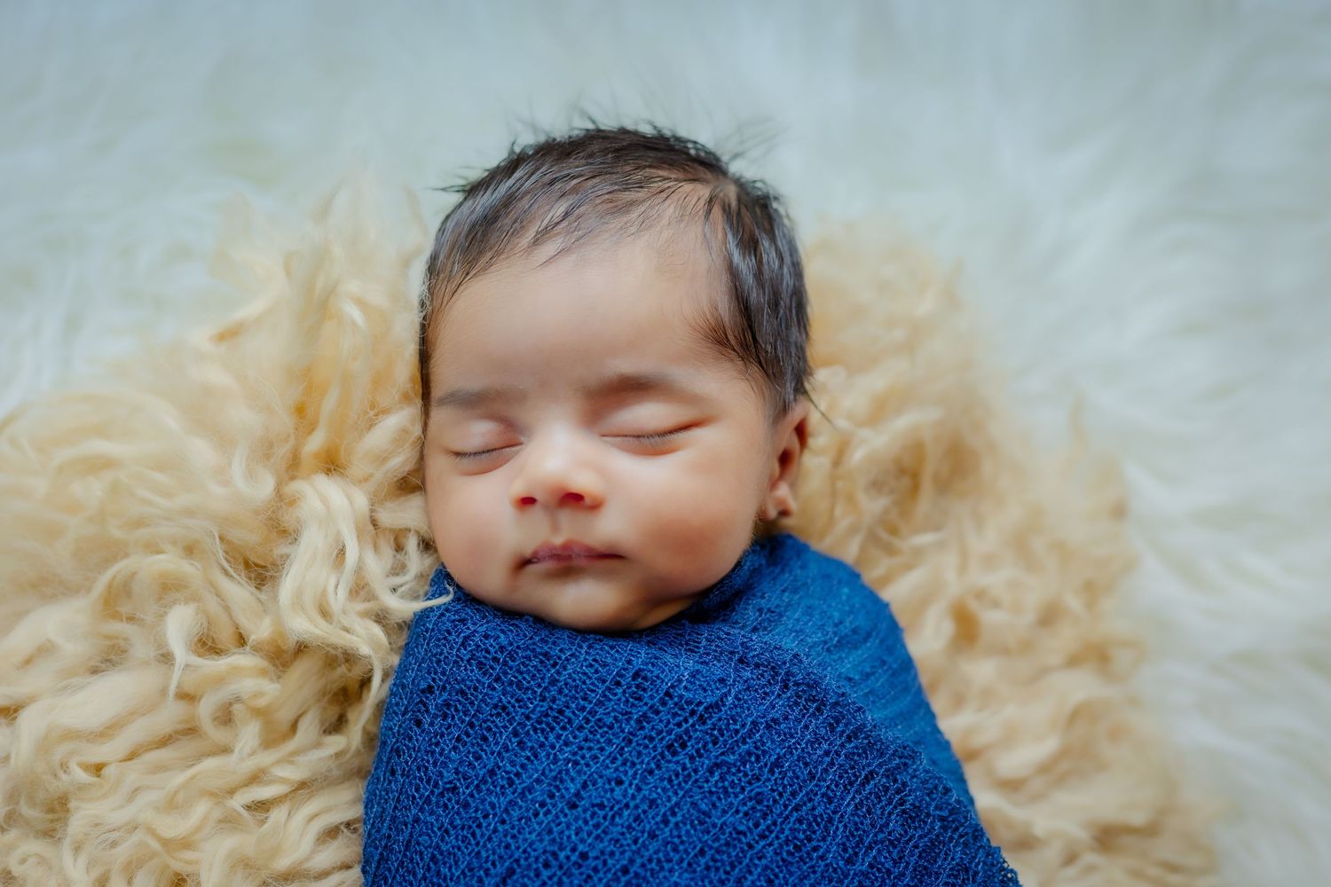 A newborn baby born soundly sleeps for a perfect newborn portrait