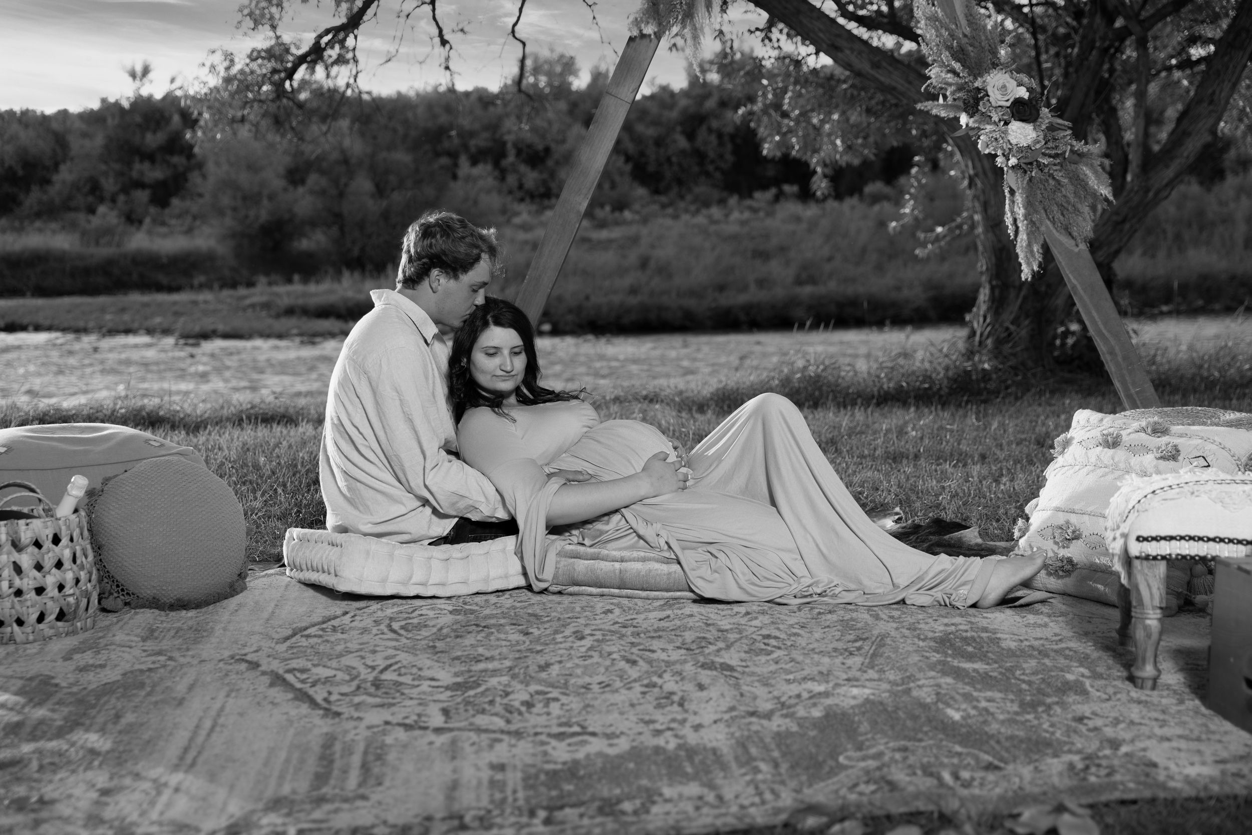 A couple relaxing on a picnic blanket in a scenic outdoor setting.
