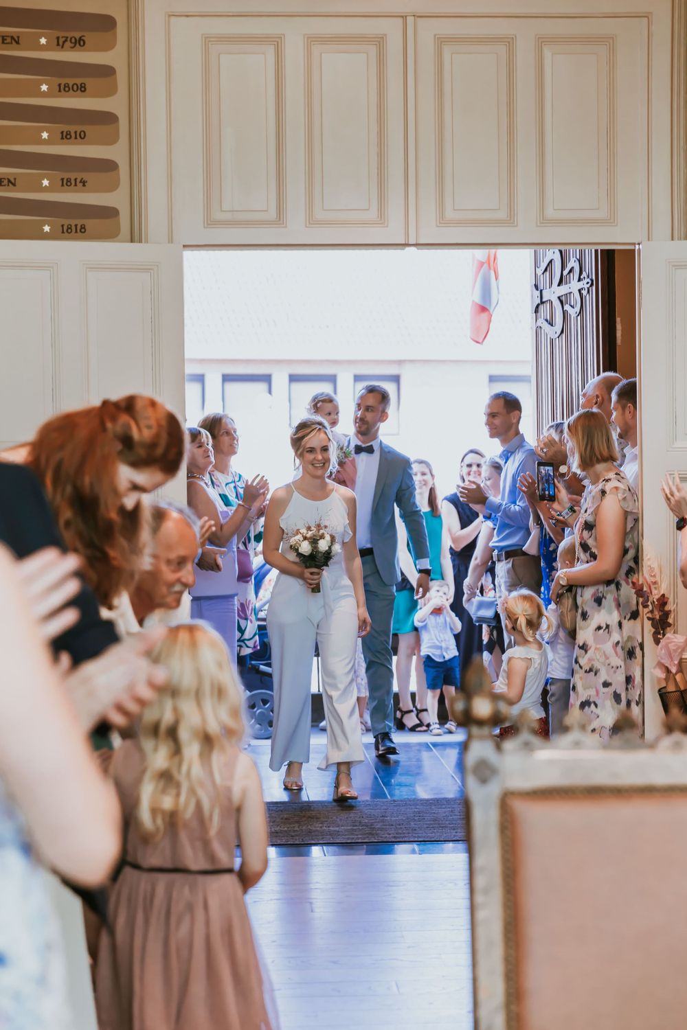 Wedding celebration in an elegant room with guests gathering to witness the ceremony.