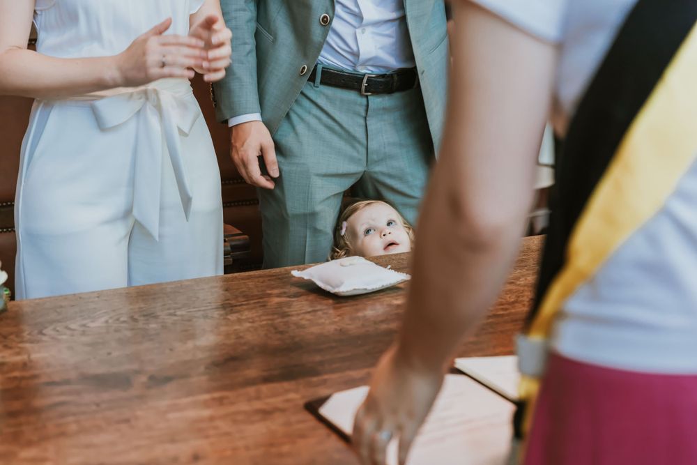 Close-up view of hands on a wooden table during a formal ceremony.
