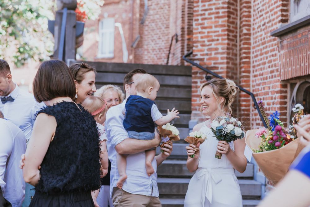 Guests gather outside a brick building during a celebration.