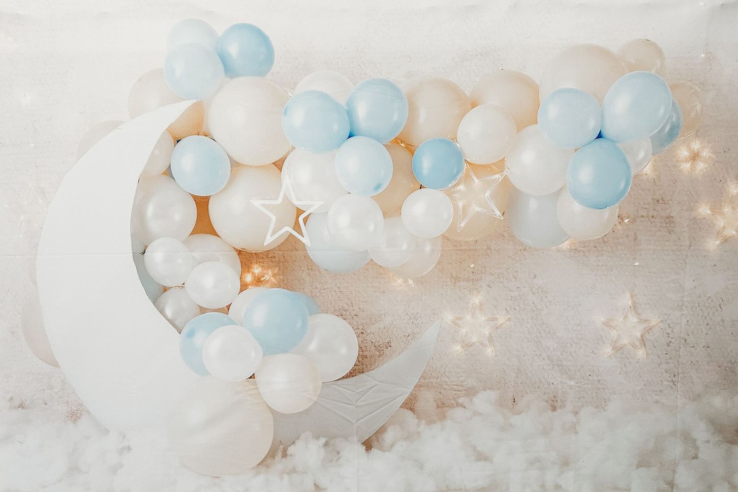 Soft pastel blue and white balloons arranged against light neutral background.