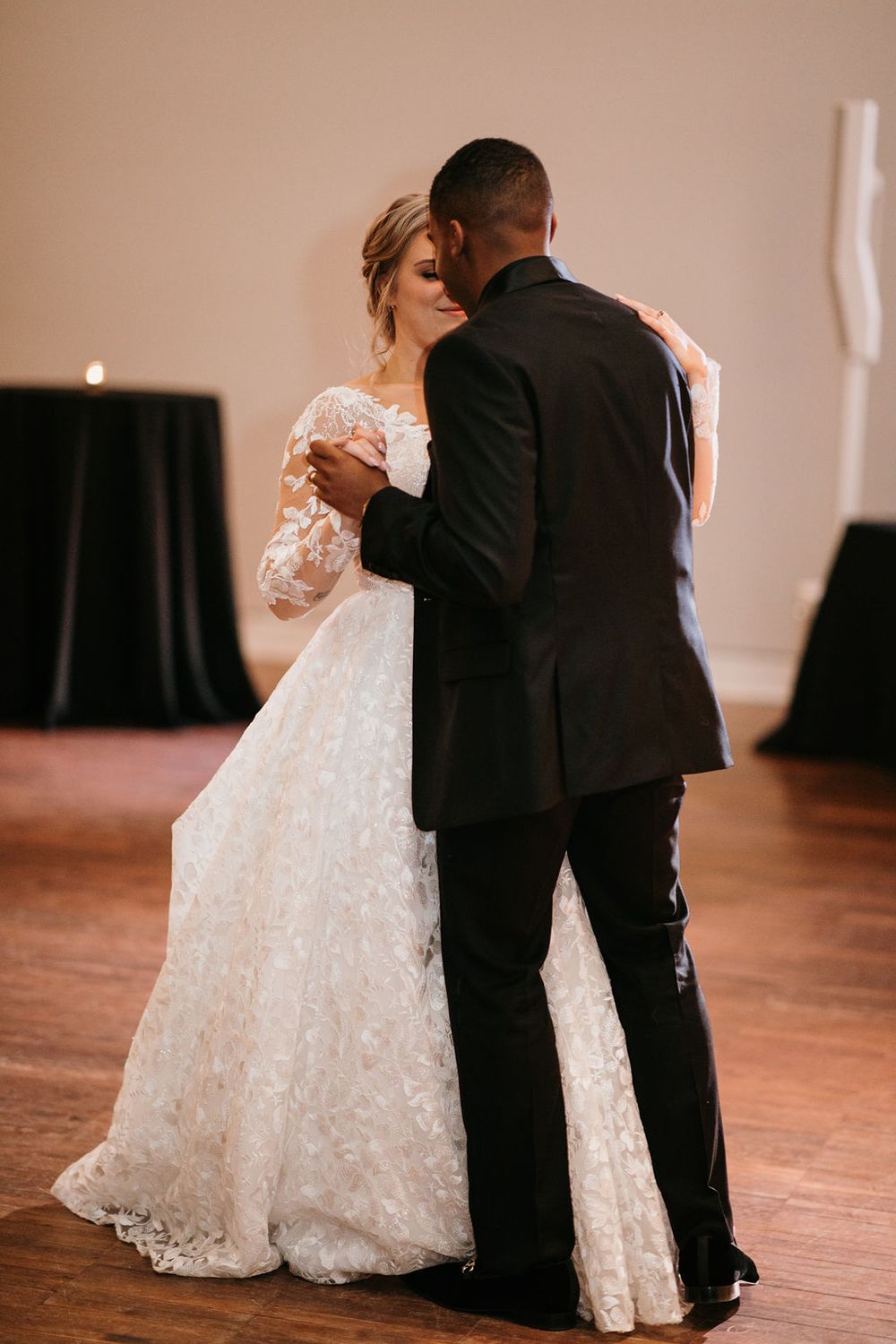 Bride and groom sharing an intimate first dance, with the bride wearing a stunning lace ballgown.