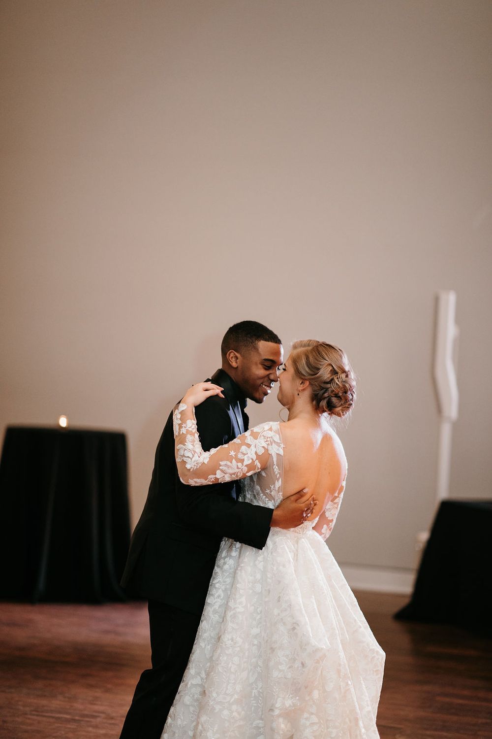 Bride and groom gazing at each other lovingly during their first dance at their wedding reception.