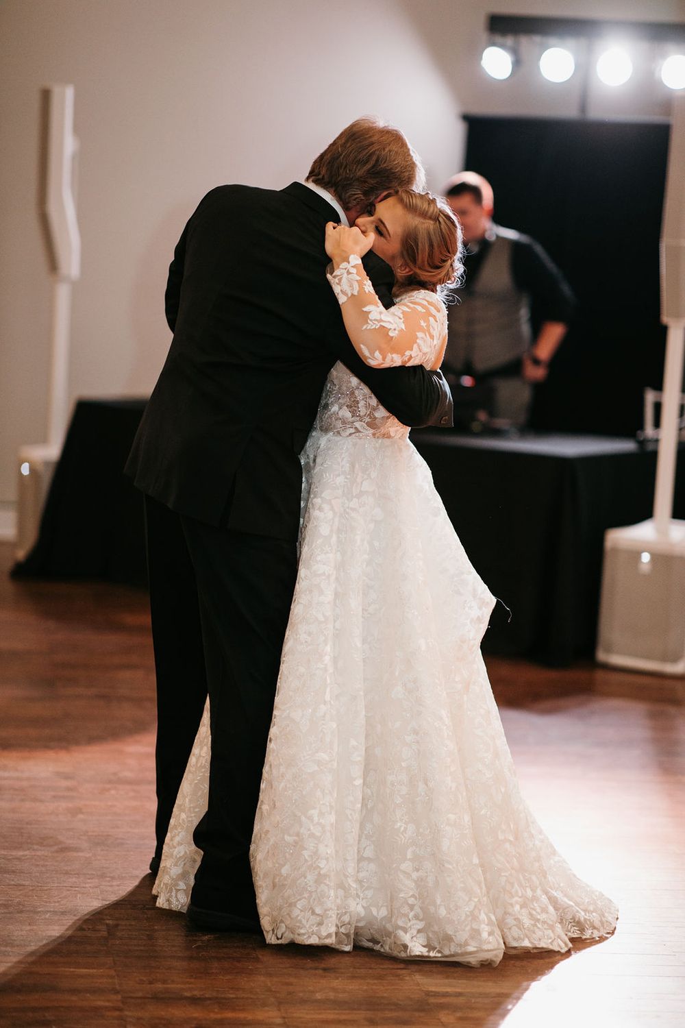 Bride and groom share an emotional first dance embrace at their wedding reception.