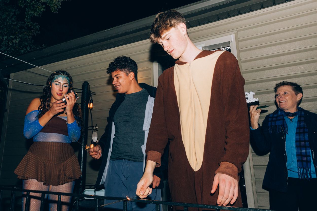 Group of young people posing and taking photos at a nighttime party.