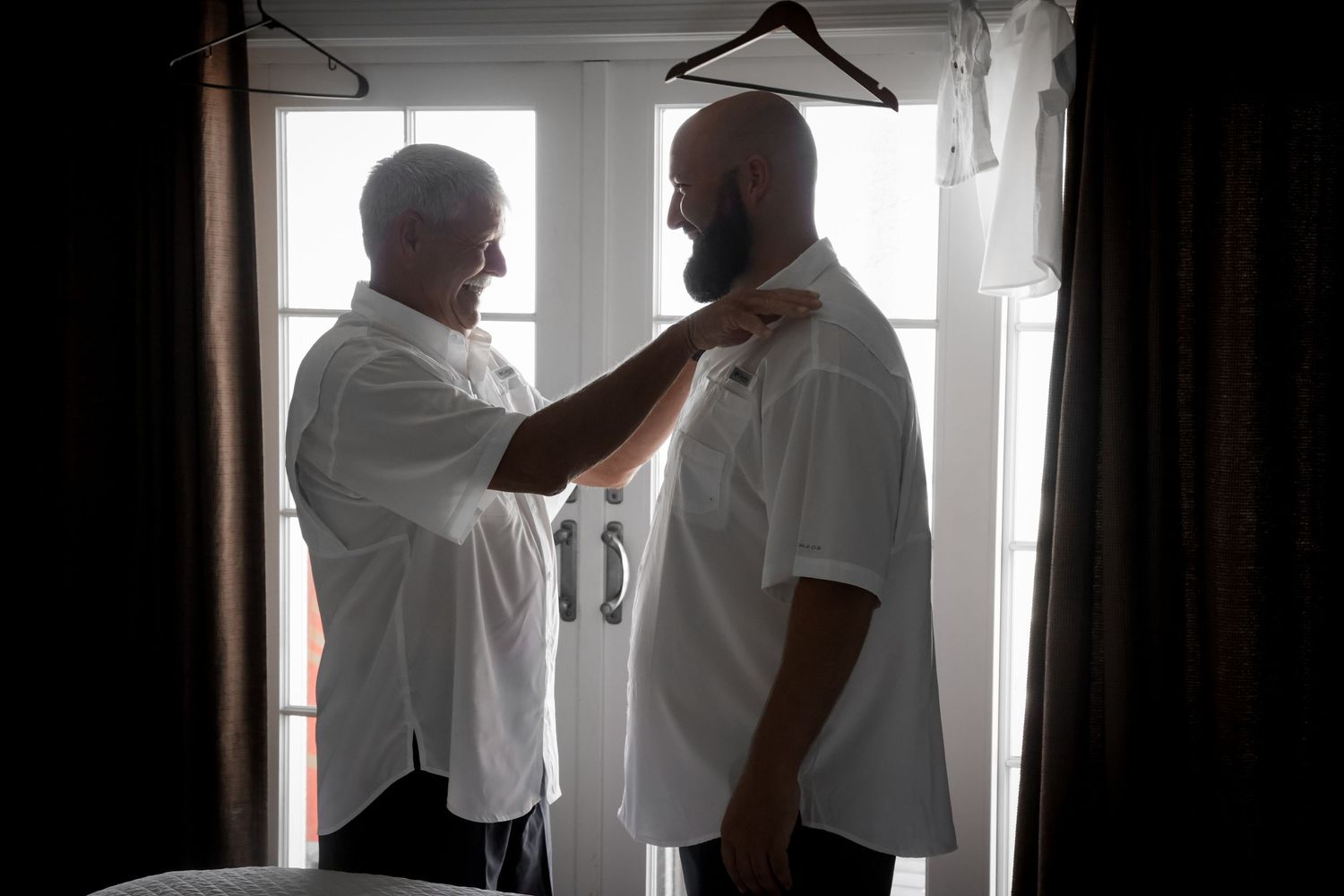 A silhouetted moment of preparation before a wedding ceremony.