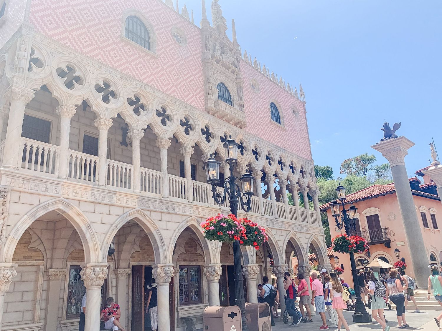 Ornate white stone building facade with Gothic arches and architectural details against blue sky.
