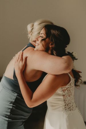 Intimate emotional embrace captured in warm lighting during wedding celebration.