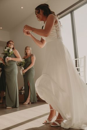 Candid moment of wedding preparations showing final adjustments to attire in natural light.