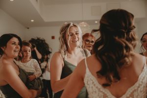 Candid moment of joyful laughter shared between wedding party members during pre-ceremony preparations.