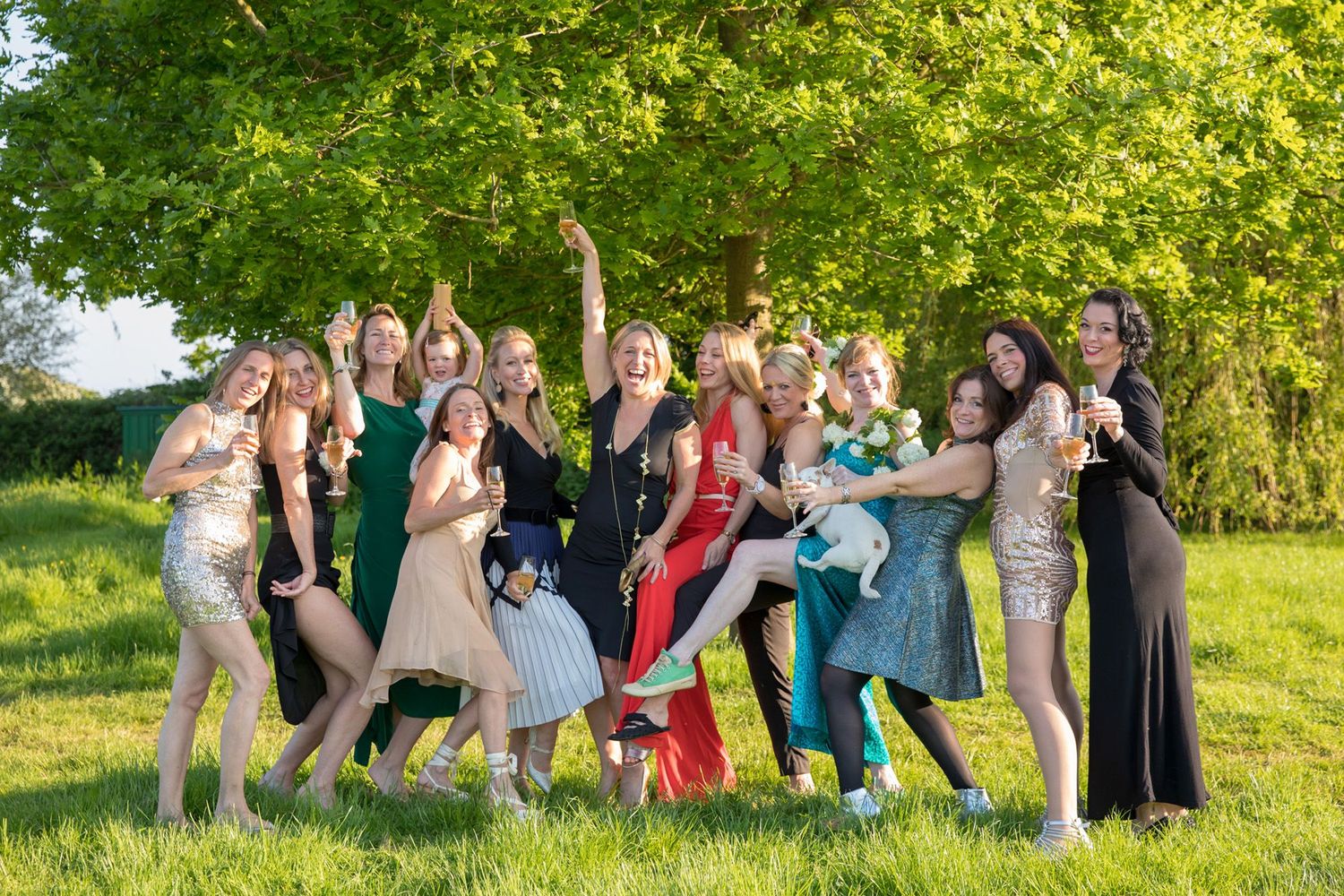 Friends gathered for a group photo in formal attire on a sunny afternoon.