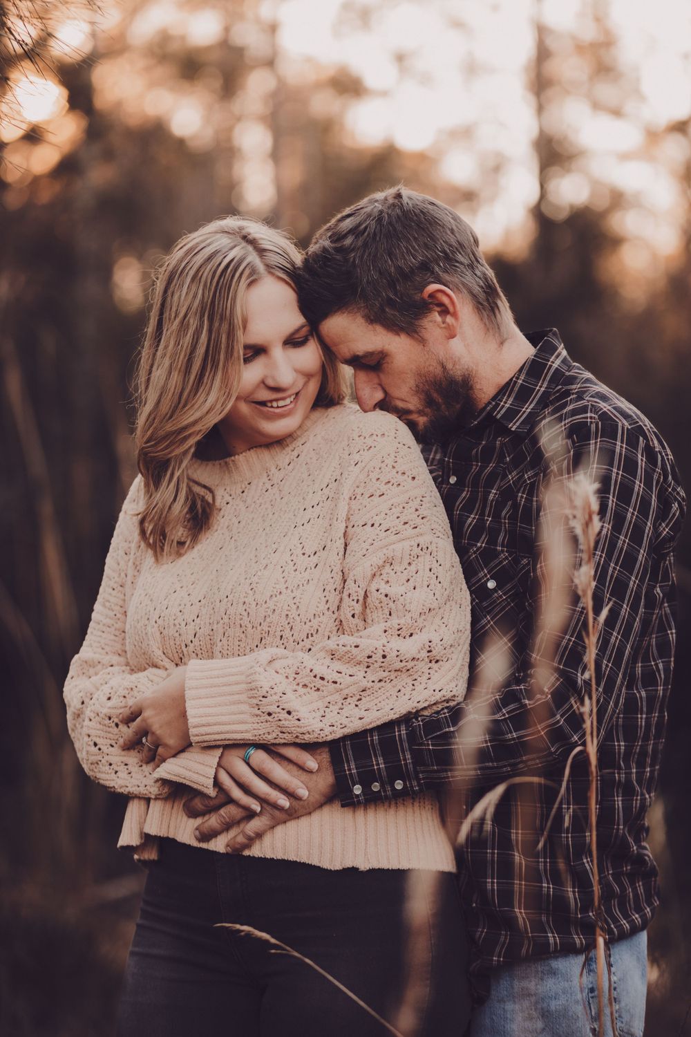 Intimate couple portrait with soft lighting showing tender moment in casual fall clothing.