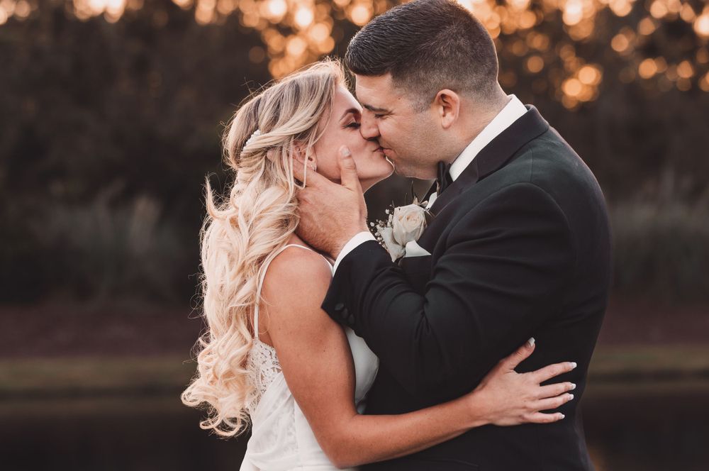 Romantic sunset wedding portrait capturing tender moment between newlyweds.