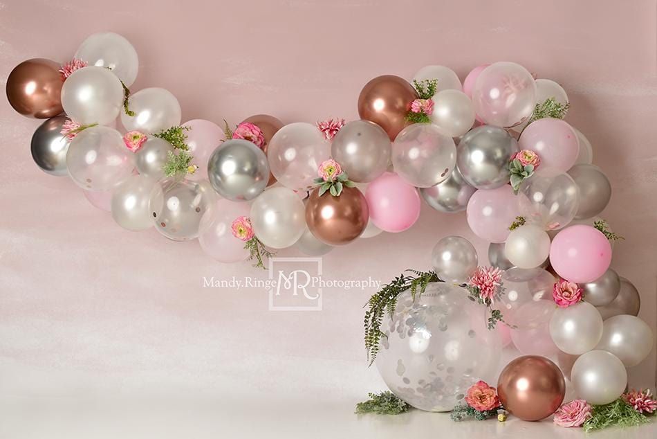 Elegant balloon arch garland in pink, rose gold, and silver with floral accents.