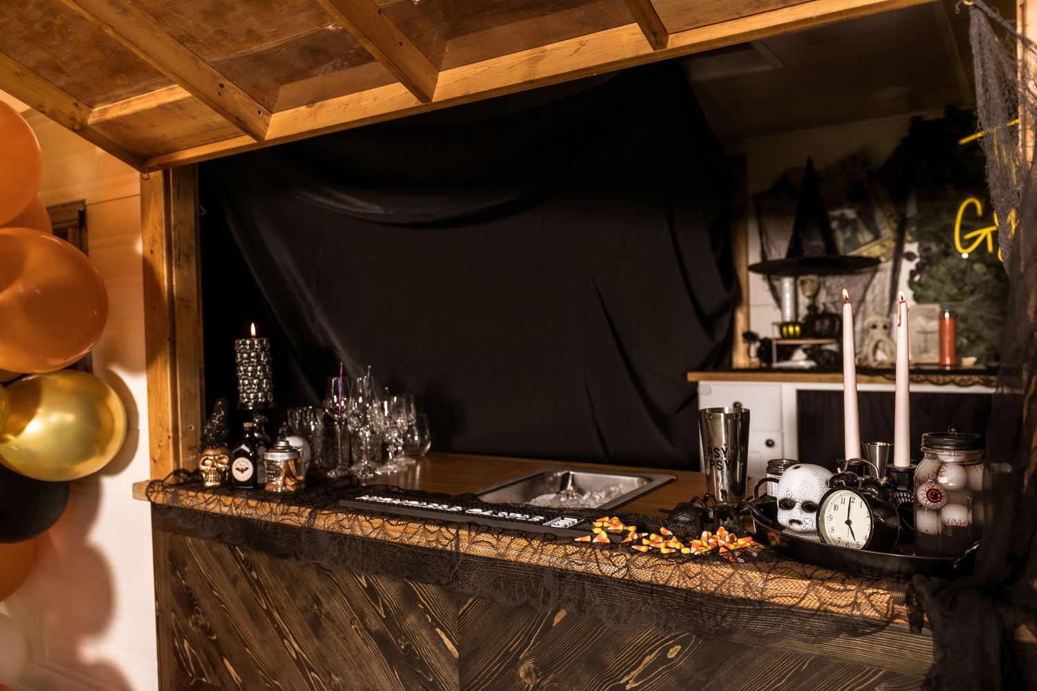 Dark Halloween-themed bar setup with gold accents and spooky decorations.
