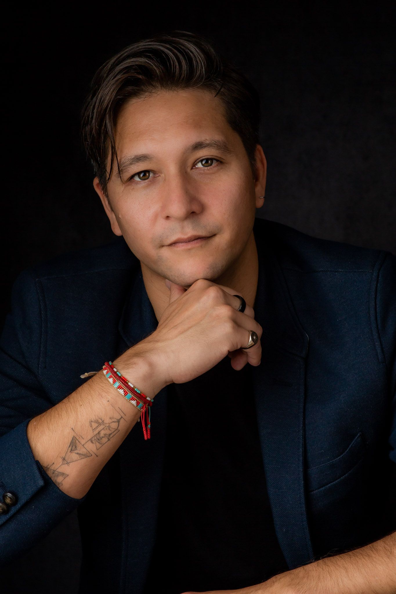Corporate headshot of Miro Fok wearing navy blue jacket on a black background by Stela McMillan Photography.