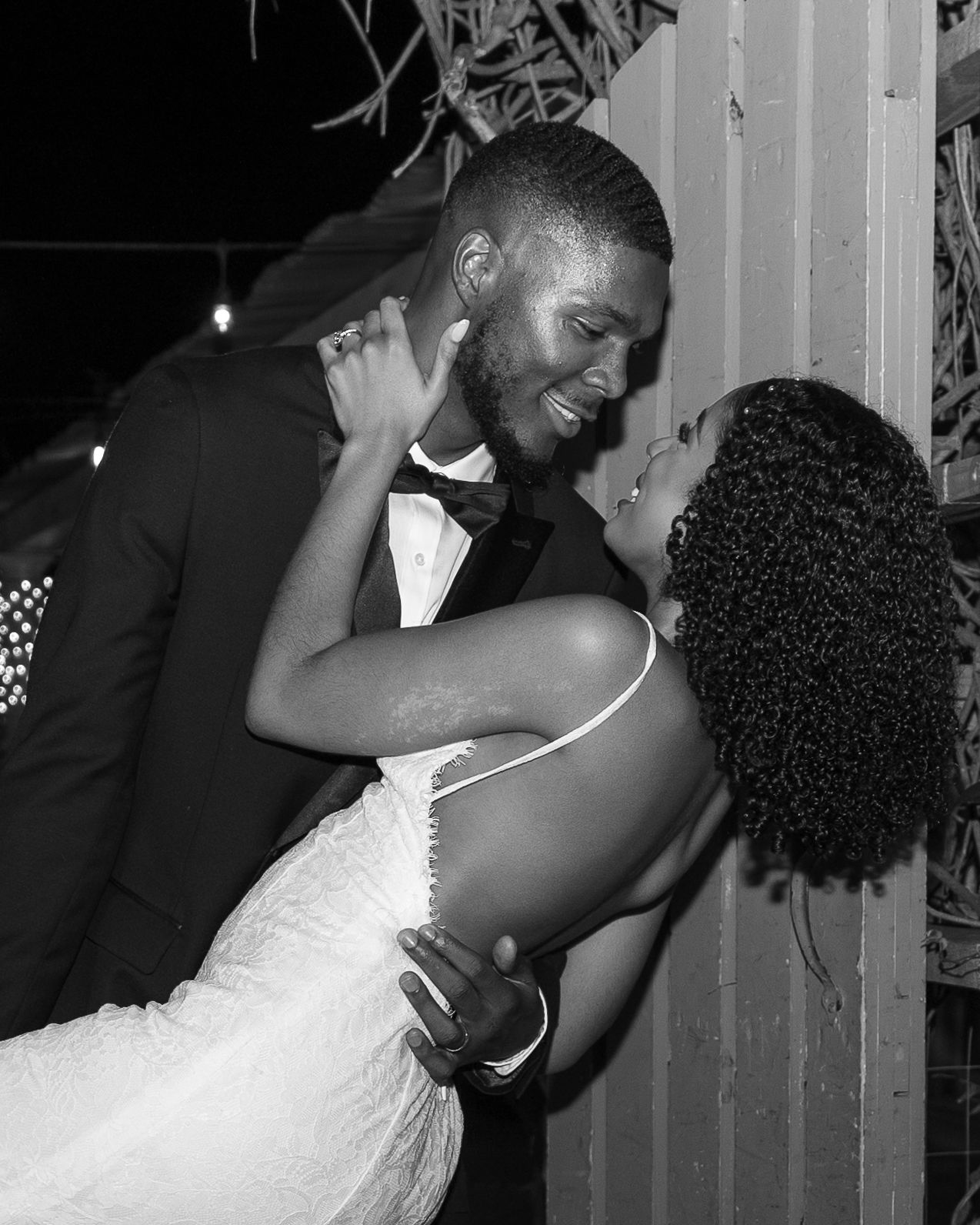 A newly married couple shares a romantic dance pose at their wedding celebration.