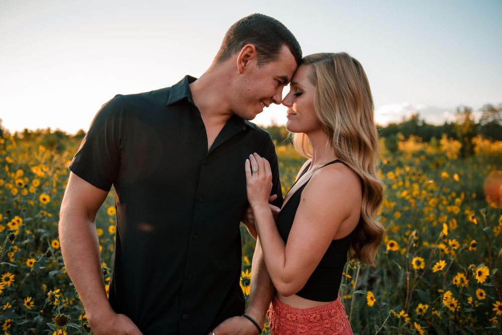 Romantic sunset portrait in a field of golden sunflowers.