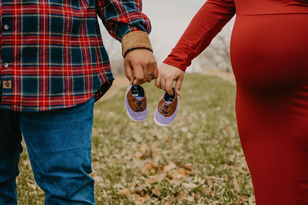 Detail shot of plaid clothing and red dress during outdoor family photoshoot.