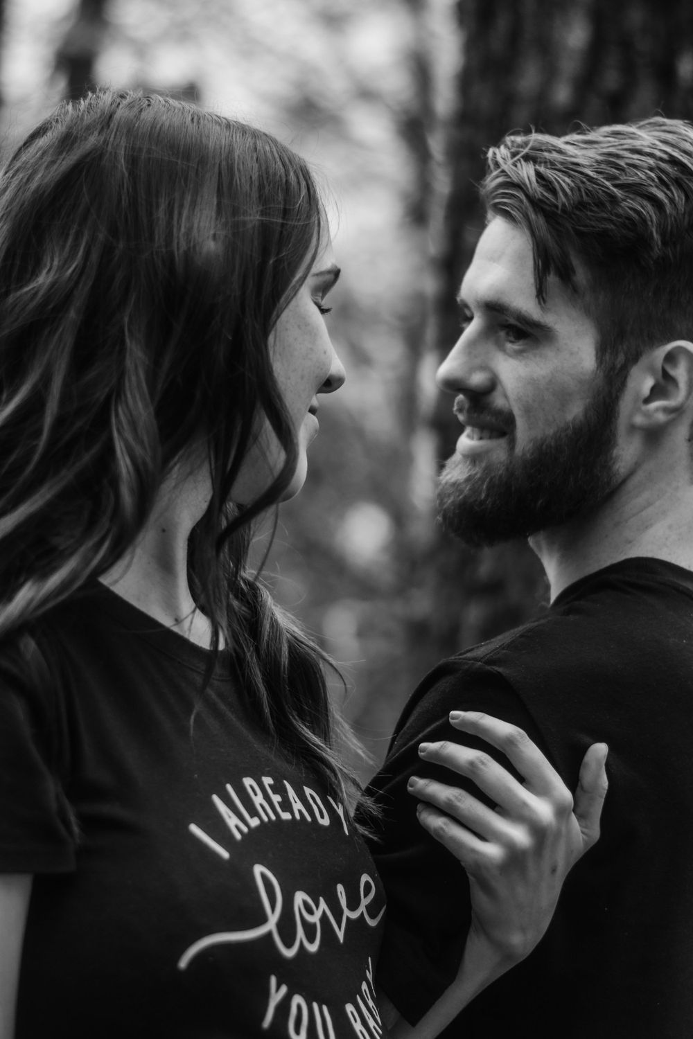 Intimate black and white portrait of couple sharing tender moments while wearing matching t-shirts.