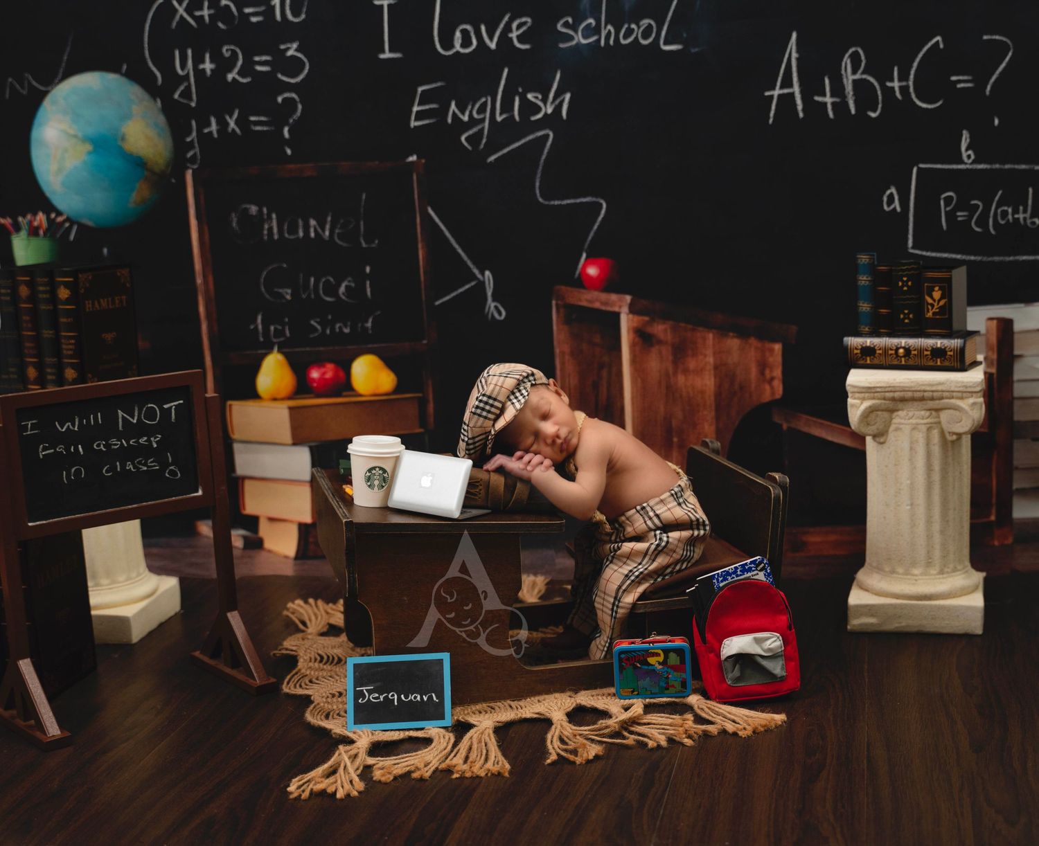 baby sleeping in miniature school desk with chalkboard, books, globe, and backpack at The Affinity Studio in St. Augustine.