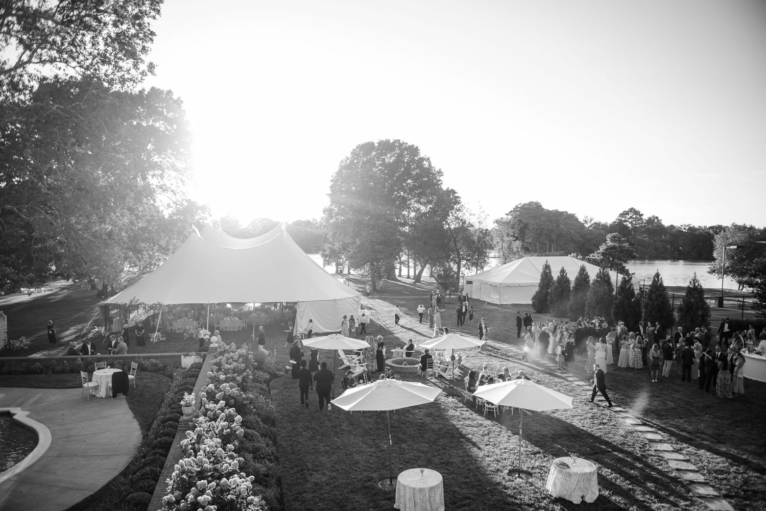 Aerial view of outdoor event venue with tents and landscaping at sunset.