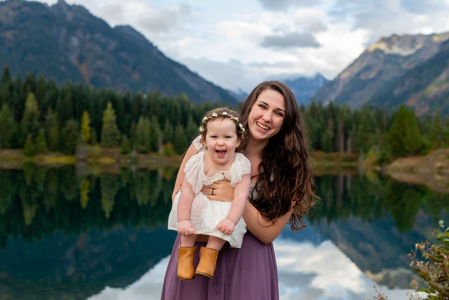 Family portraits by mountain lake with stunning wilderness backdrop.