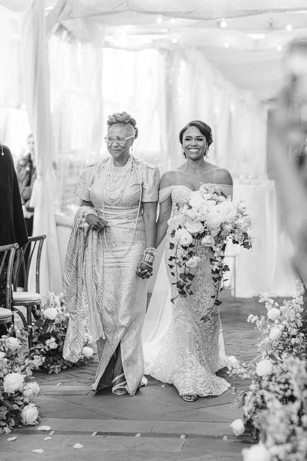 Black and white photo of formal processional with cascading white bouquet.