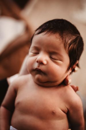 Artistic close-up portraits of a sleeping newborn in sepia tones.