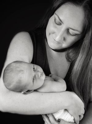 Black and white intimate portraits showing tender moments between parent and newborn.