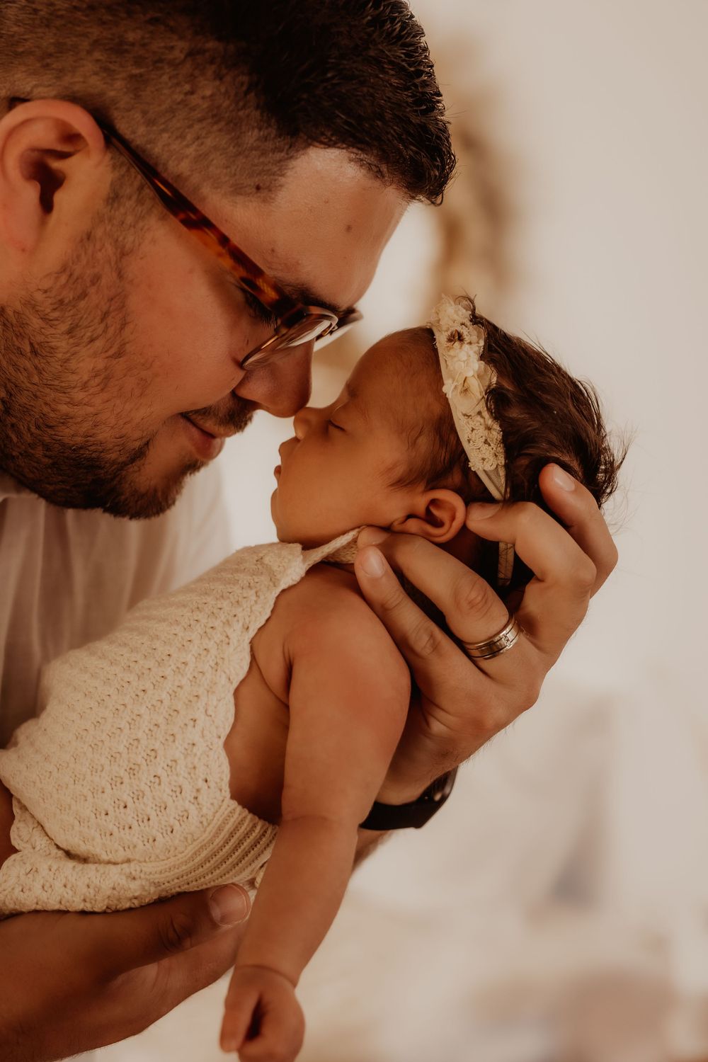A tender moment between parent and baby captured in a series of warm-toned photographs.