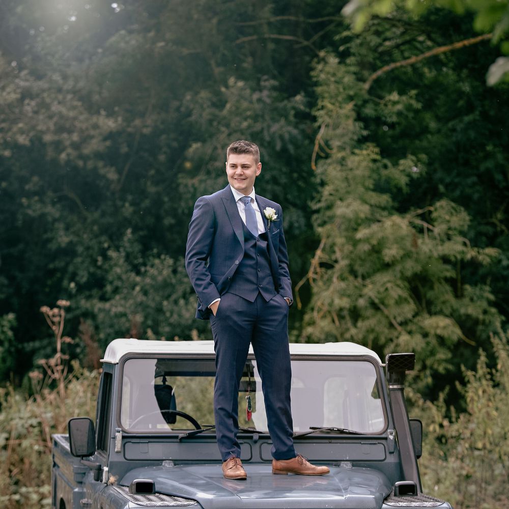 The groom standing on top of his truck for his groom portraits.