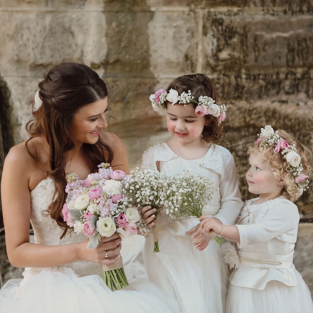 Bride with her little flower girls comparing bouquets.