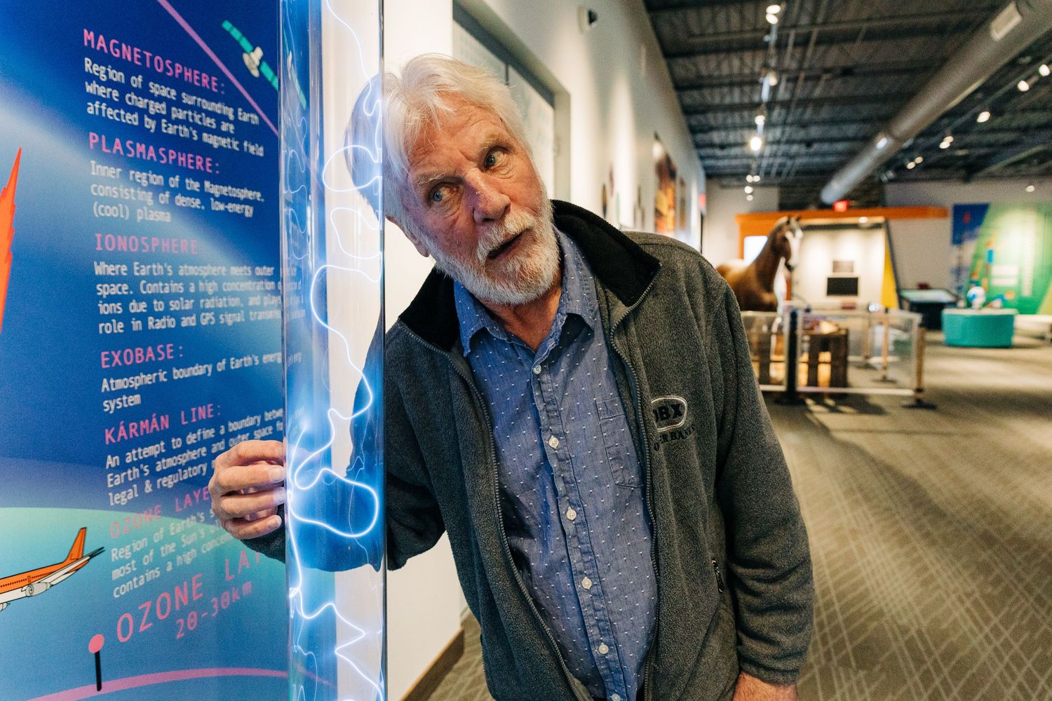 man playing with magnetosphere exhibit at Monroe Science Center