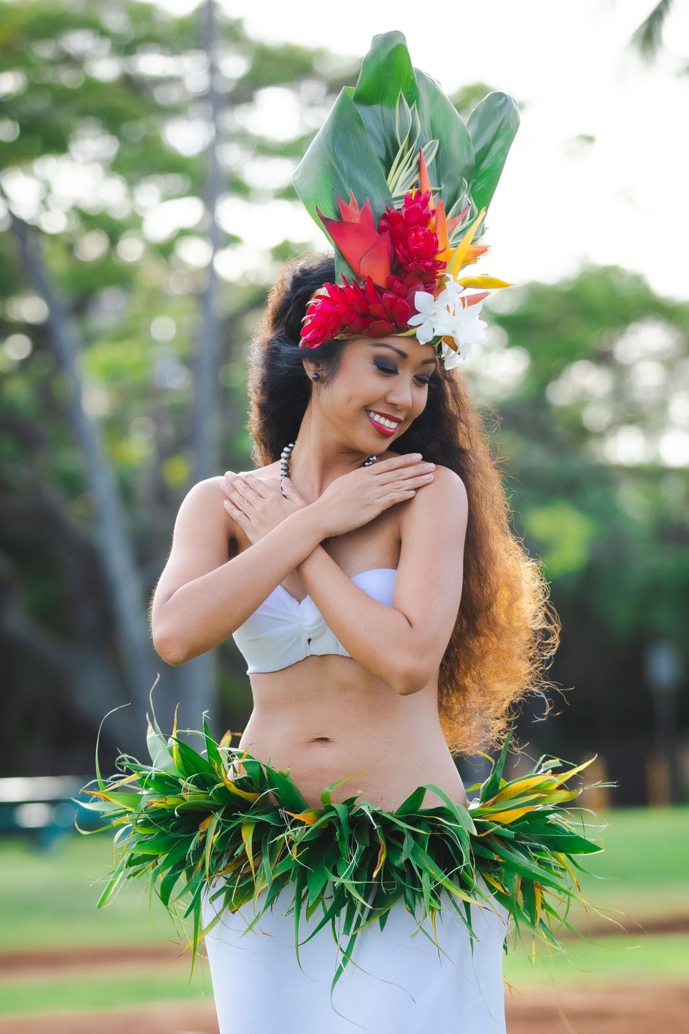 Hula dancer in traditional costume with tropical flower headpiece.