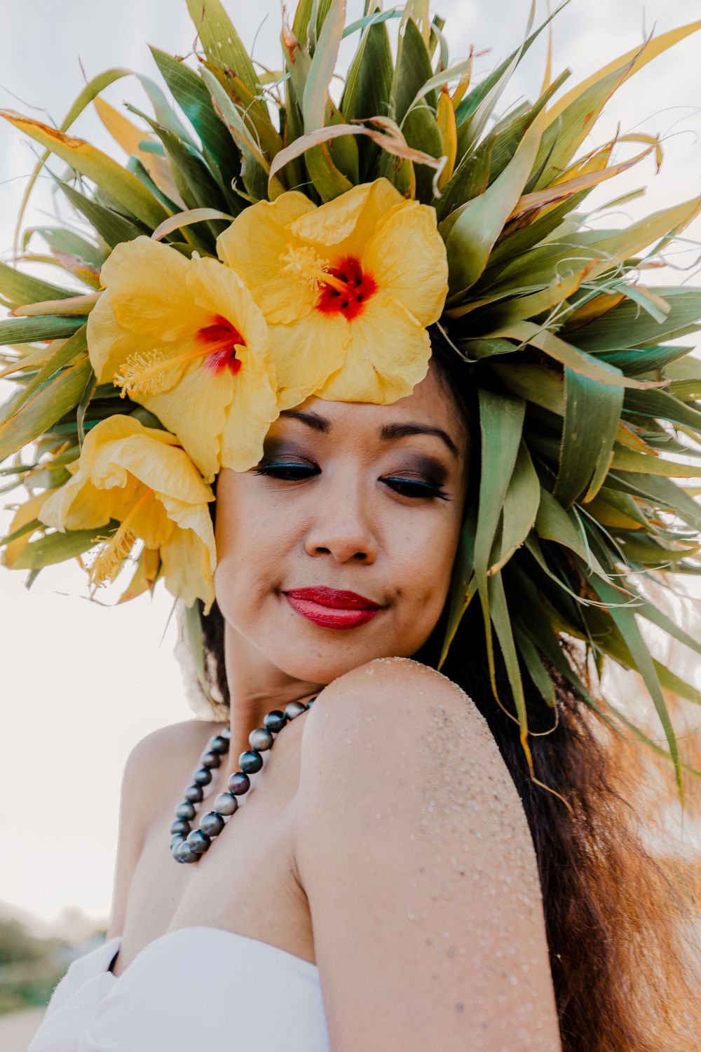 Close-up portrait showcasing elaborate Hawaiian headdress with yellow hibiscus flowers.
