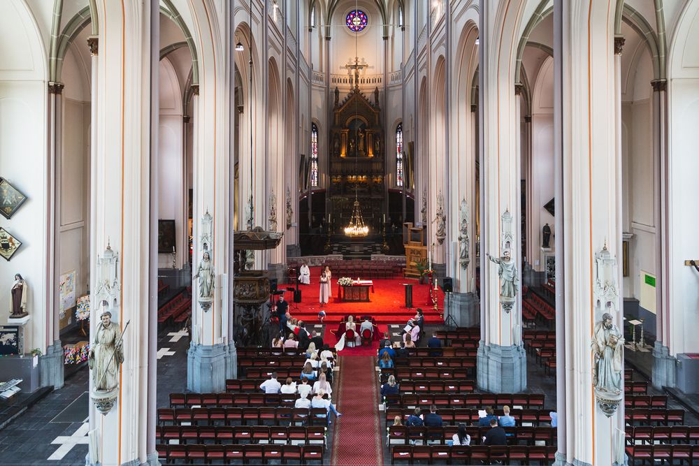 Gothic church interior with high vaulted ceilings and red carpet leading to altar.