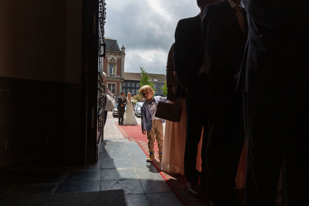 A candid moment captured through a doorway during a wedding celebration.