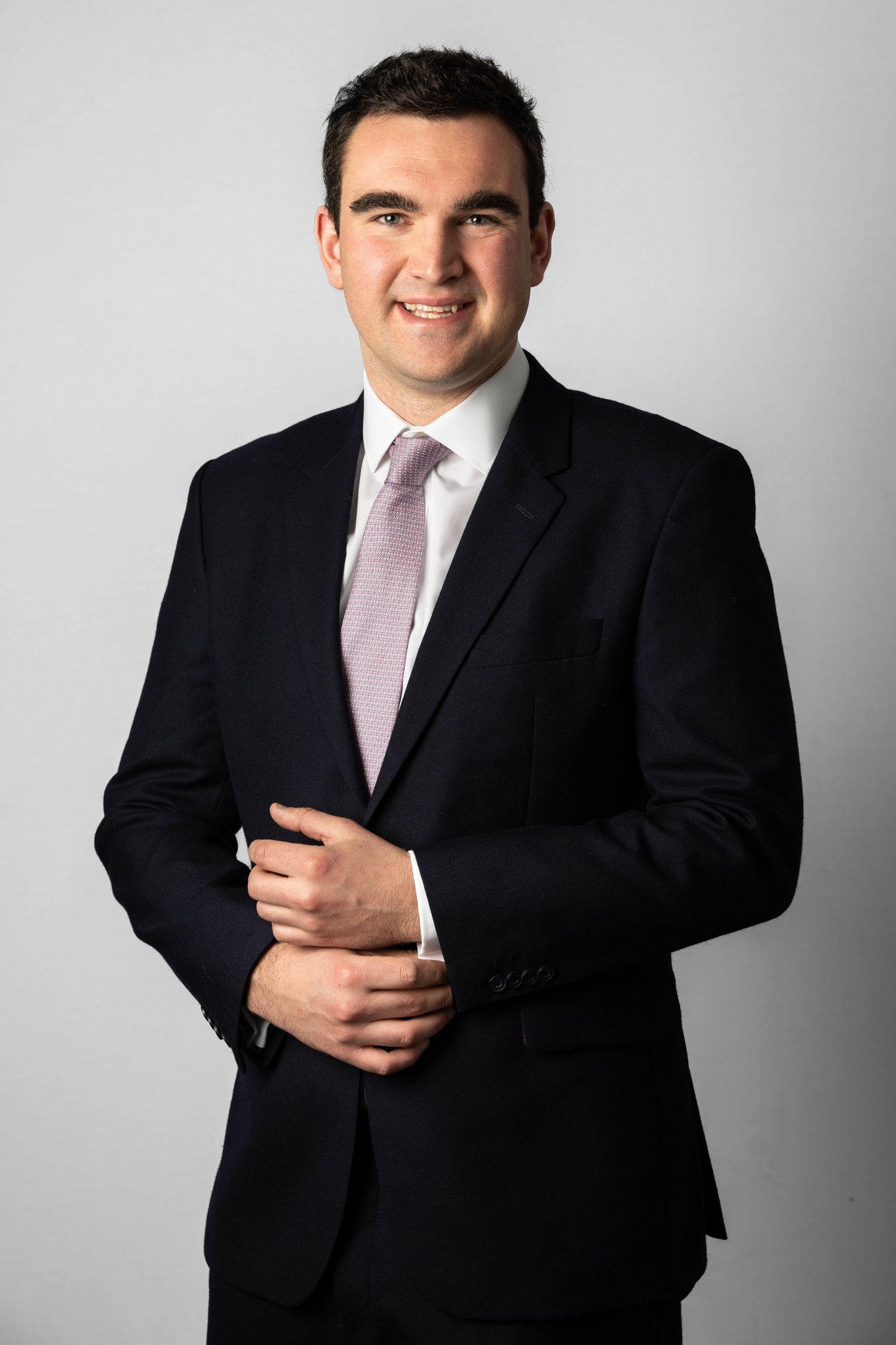 Business portrait of a man against a plain background