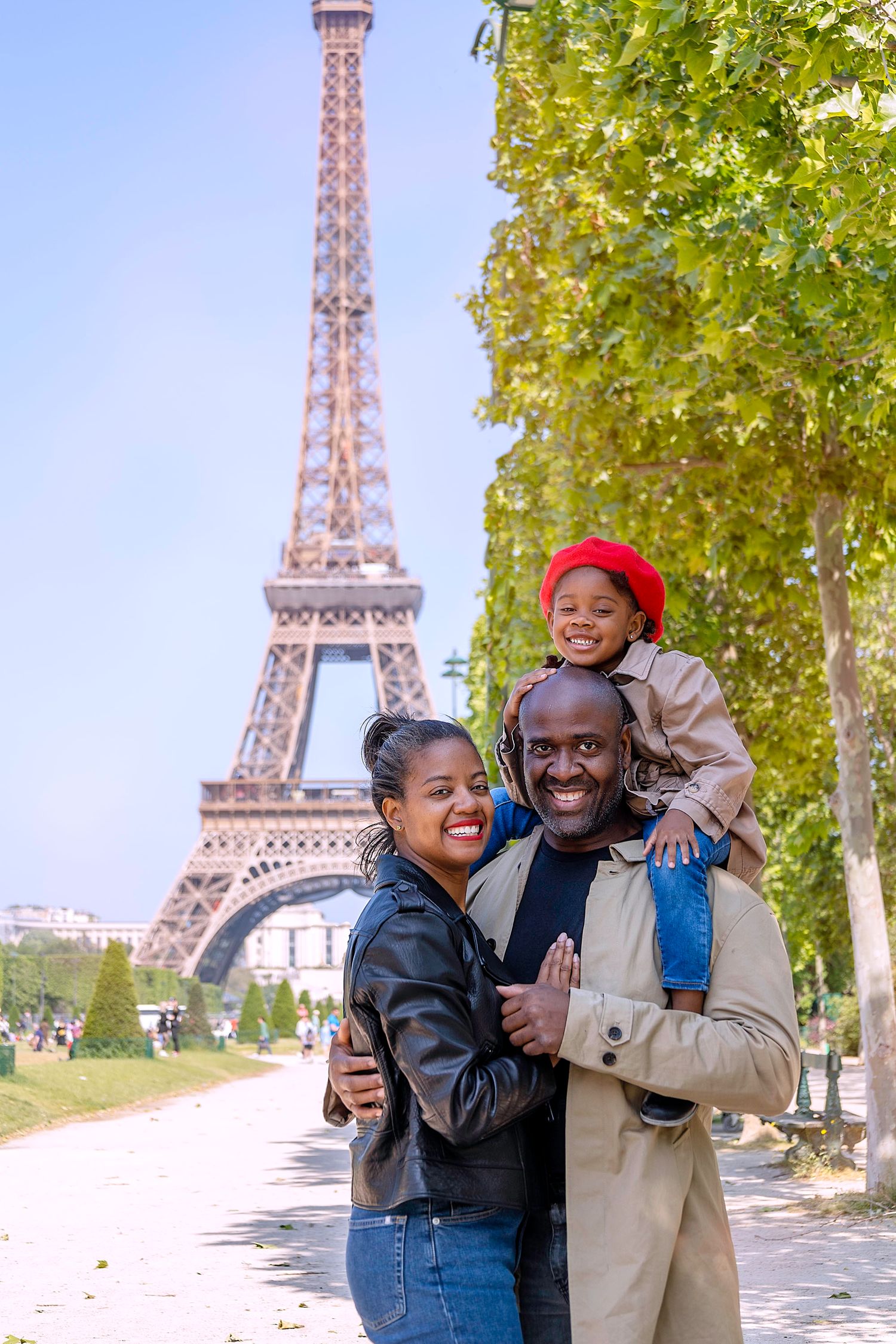 Black family smiling in front of Eiffel Tower