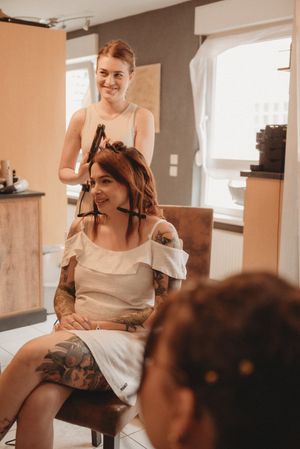 A hairstyling session in progress in a bright, modern room setting.