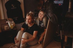People relaxing in a casual indoor setting with moody ambient lighting.