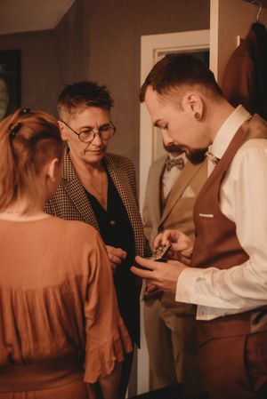 Wedding preparations showing a group engaged in conversation in a cozy indoor setting.