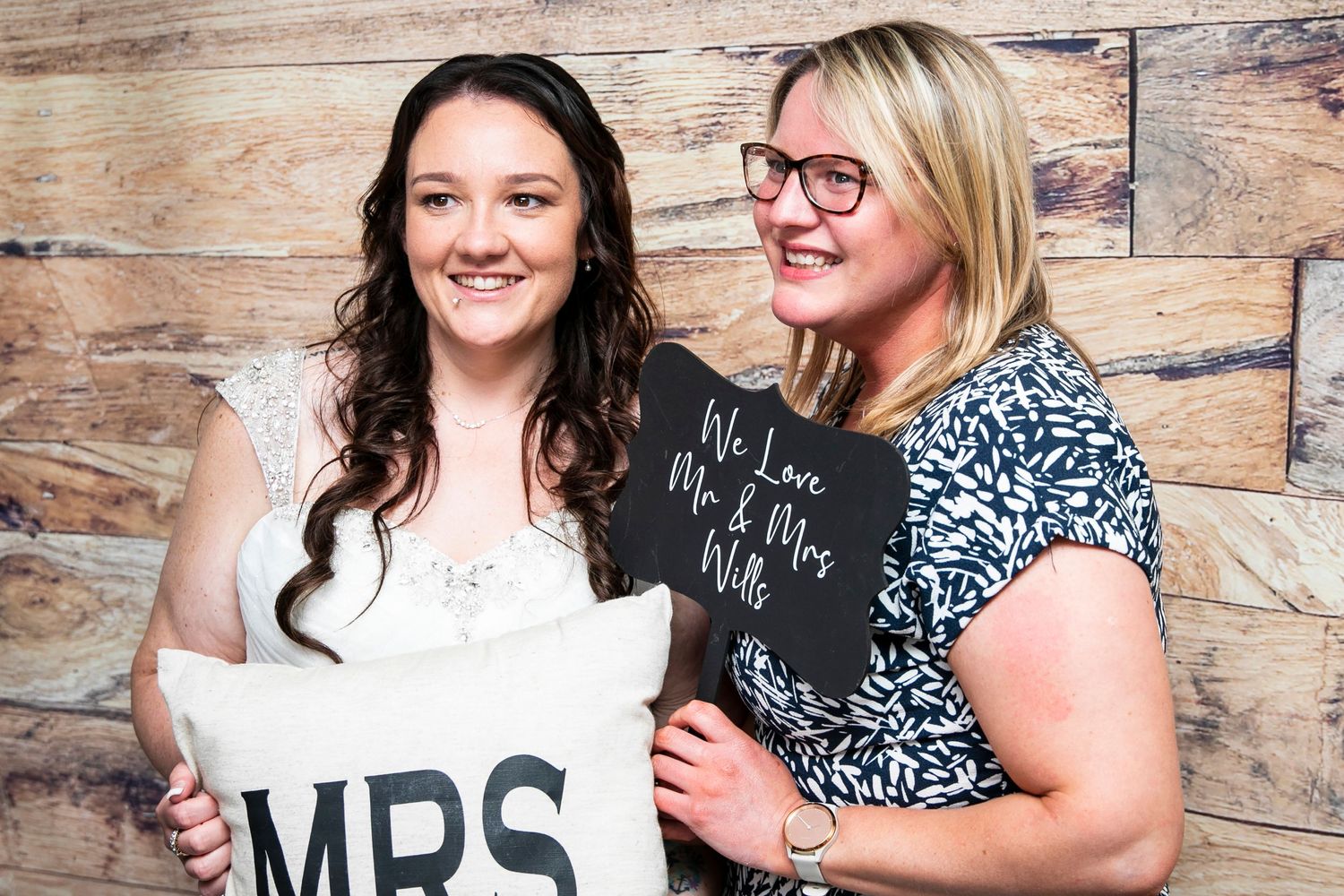 Joyful wedding celebration moments captured against rustic wooden backdrop.