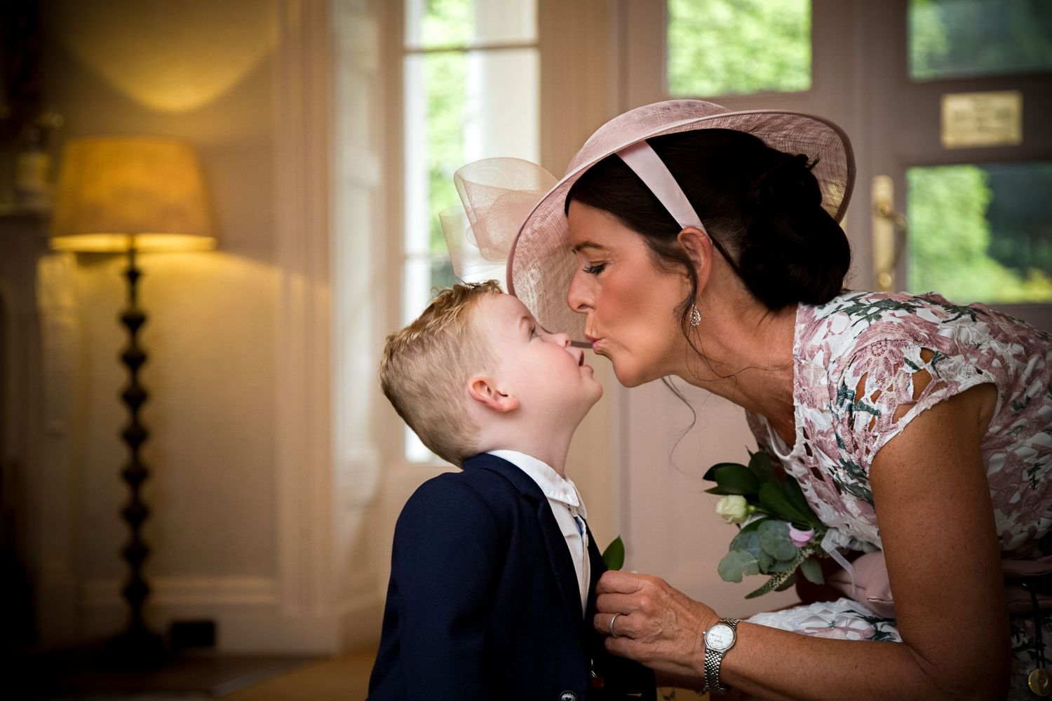 Tender moment captured in warm indoor lighting with soft window glow.