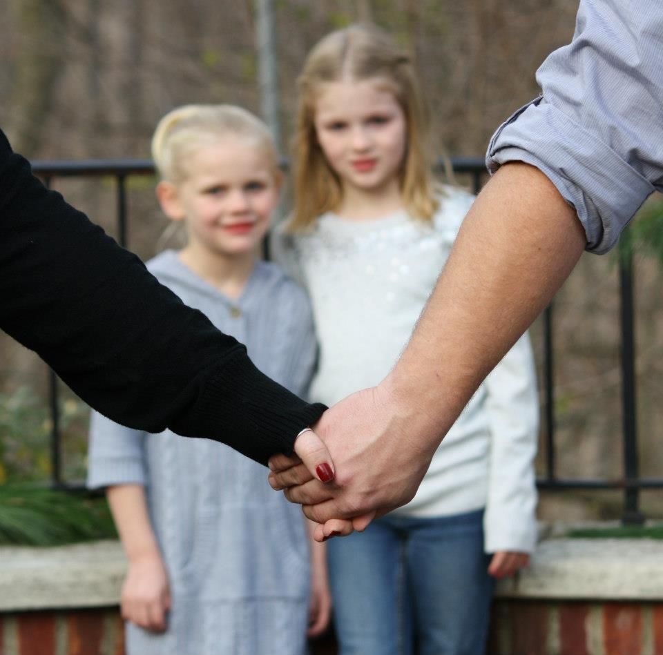 Close-up of hands joining together in a supportive gesture.