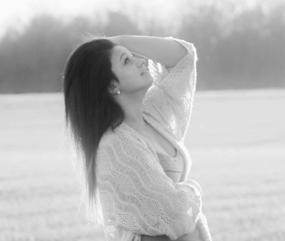 Dreamy black and white portrait of someone in a knit sweater outdoors.