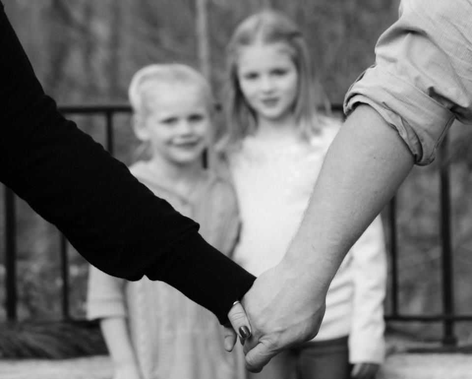 Black and white image of hands clasped together in unity.