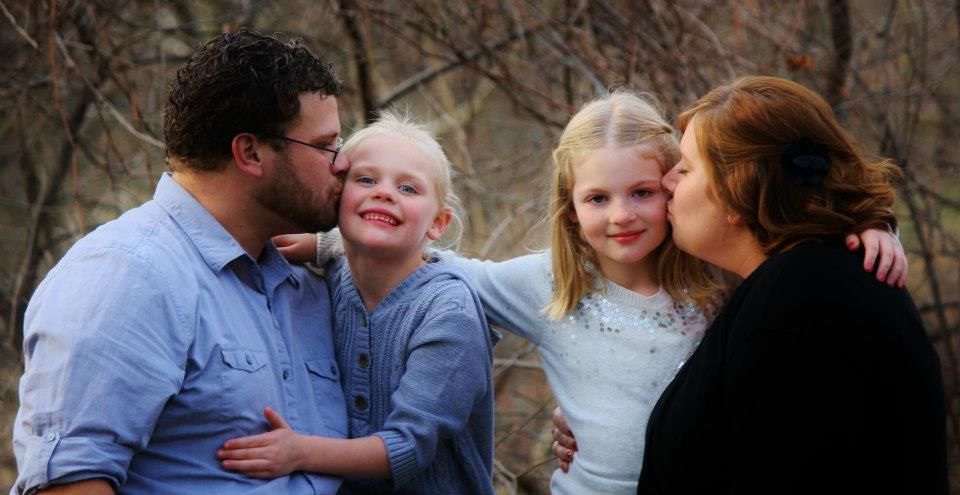 Intimate family portrait showing affection and closeness outdoors.